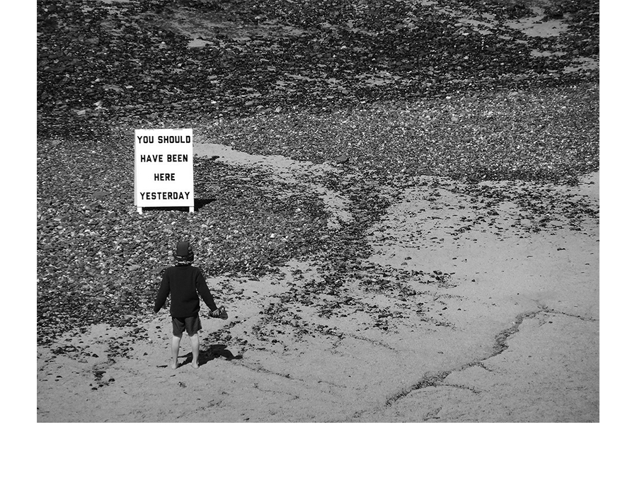 Black and white text A frame text sign on beach with young boy Cornwall surfing artwork brexit